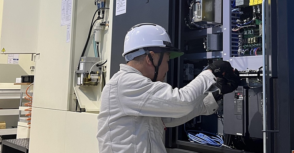 制御盤の内部を調整する作業員